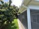 Exterior view of the long screened porch with mature trees, giving shade and seclusion at 11725 Cuxham Dr, Orlando, FL 32837