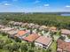 Aerial view of neighborhood features well maintained lawns, mature trees and landscaping, and beautiful homes with dark tile roofs at 11741 Savona Way, Orlando, FL 32827