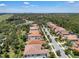 An aerial view of a large neighborhood with lush trees, meticulously-kept lawns, and beautiful homes with red tile roofs at 11741 Savona Way, Orlando, FL 32827