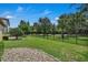 Well-maintained backyard with lush green grass, mature trees, and a stone-lined garden bed at 11741 Savona Way, Orlando, FL 32827