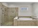 Luxurious bathroom featuring a glass-enclosed shower and a separate soaking tub for ultimate relaxation at 11741 Savona Way, Orlando, FL 32827