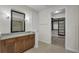 Bathroom featuring dark wood cabinets, granite countertops, and walk-in closet access at 11741 Savona Way, Orlando, FL 32827