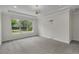 Bright bedroom with a tray ceiling, large window offering abundant natural light, and neutral carpeting at 11741 Savona Way, Orlando, FL 32827