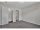 A neutral-toned bedroom features carpeted floors, closet, and a door to another room in the property at 11741 Savona Way, Orlando, FL 32827