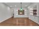 Formal dining room with hardwood floors, stylish lighting fixture, and custom built-in storage with shelves at 11741 Savona Way, Orlando, FL 32827