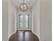 Bright foyer features dark wood floors, white walls, and decorative glass double doors with statement light fixture at 11741 Savona Way, Orlando, FL 32827