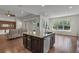 Open kitchen layout with an island featuring granite countertops and views of an adjacent living area at 11741 Savona Way, Orlando, FL 32827