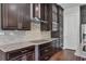 Modern kitchen showcasing custom dark wood cabinets, granite countertops, and stainless steel appliances at 11741 Savona Way, Orlando, FL 32827