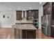 Gourmet kitchen featuring dark wood cabinets, stainless steel appliances, and a granite topped island at 11741 Savona Way, Orlando, FL 32827