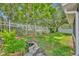 Landscaped backyard featuring lush lawn, mature trees, flower beds, and a charming fish pond at 1181 Welch Hill Cir, Apopka, FL 32712