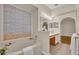 Bright bathroom featuring a soaking tub, large mirror, and double sink vanity at 1181 Welch Hill Cir, Apopka, FL 32712