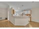 Bright, open kitchen with breakfast bar, white cabinetry, and laminate wood flooring flowing into the living area at 1181 Welch Hill Cir, Apopka, FL 32712
