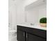 Bathroom with black vanity, white countertop and toilet and a decorative green plant at 1209 Deepwater Cir, Eagle Lake, FL 33839