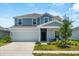 Charming two-story home with a well-maintained lawn and a two-car garage on a sunny day at 1209 Deepwater Cir, Eagle Lake, FL 33839