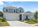 Beautiful two-story home with a two-car garage, pretty landscaping, and a cozy seating area at 1209 Deepwater Cir, Eagle Lake, FL 33839