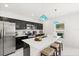 Well-lit kitchen featuring an island with seating, modern appliances, and a view of the backyard at 1209 Deepwater Cir, Eagle Lake, FL 33839