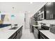 Stylish kitchen with an island, stainless steel appliances, and sleek black cabinetry at 1209 Deepwater Cir, Eagle Lake, FL 33839