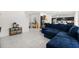 Open-concept living area with tile floors, a blue sectional sofa, and stylish decor at 1209 Deepwater Cir, Eagle Lake, FL 33839