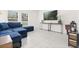 Spacious living room with tile flooring, a plush blue sofa, and a view of the outdoors at 1209 Deepwater Cir, Eagle Lake, FL 33839