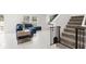 Bright living room featuring tile floors, a comfortable blue sofa, and stairs to the upper level at 1209 Deepwater Cir, Eagle Lake, FL 33839