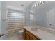 Bright bathroom featuring a tub/shower with a striped curtain and vanity with light wood cabinets at 1245 Reagans Reserve Blvd, Apopka, FL 32712