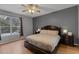 This bedroom features a ceiling fan, a gray accent wall, a spacious window and wood floors at 1245 Reagans Reserve Blvd, Apopka, FL 32712