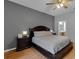 This bedroom features a ceiling fan, a gray accent wall, wood floors, and an ensuite bathroom at 1245 Reagans Reserve Blvd, Apopka, FL 32712