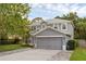 Gray two-story home with a two-car garage, green lawn, and landscaping at 1245 Reagans Reserve Blvd, Apopka, FL 32712