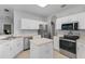 Modern kitchen with white cabinets, stainless steel appliances, and a tile backsplash at 1245 Reagans Reserve Blvd, Apopka, FL 32712