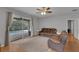 Living room featuring leather seating, a ceiling fan, and sliding glass doors leading to a pool at 1245 Reagans Reserve Blvd, Apopka, FL 32712