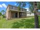 Exterior home view featuring a covered patio and well-maintained lawn at 12824 Cloverdale Ln, Clermont, FL 34711