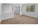 Bonus room featuring an archway, neutral carpet, white walls, and large windows at 12824 Cloverdale Ln, Clermont, FL 34711
