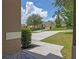 Open view from front door with a sunny driveway and mature landscaping at 12824 Cloverdale Ln, Clermont, FL 34711