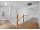 Upstairs hallway featuring a staircase with a wooden railing and neutral carpet at 12824 Cloverdale Ln, Clermont, FL 34711