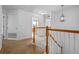 Hallway featuring a staircase with wooden railing, neutral carpet, and white walls at 12824 Cloverdale Ln, Clermont, FL 34711