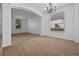 Spacious living room featuring neutral carpet and a chandelier at 12824 Cloverdale Ln, Clermont, FL 34711