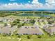 Aerial view features a community nestled by a lake, blending residences with serene natural beauty at 130 Club Villas Ln, Kissimmee, FL 34744