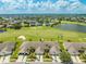 Aerial view showcases the community by a golf course, blending residences with recreational greenspace at 130 Club Villas Ln, Kissimmee, FL 34744