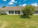 A lush, green backyard of a home showcasing a well-maintained lawn and landscaping at 130 Club Villas Ln, Kissimmee, FL 34744