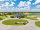 Stunning aerial view of community clubhouse with manicured lawns, lush landscaping and golf course in background at 130 Club Villas Ln, Kissimmee, FL 34744