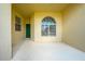Covered front porch featuring an arched window, with a green front door at 130 Club Villas Ln, Kissimmee, FL 34744