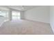 Spacious living room with neutral carpet, a ceiling fan, and sliding glass doors to the screened lanai at 130 Club Villas Ln, Kissimmee, FL 34744