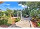 Landscaped backyard featuring stone pavers, lush greenery, and outdoor dining area for gatherings at 13822 Darchance Rd, Windermere, FL 34786