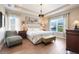 Bedroom featuring tray ceiling, light wood floors, and windows that offer natural light at 13822 Darchance Rd, Windermere, FL 34786