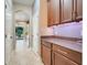 Butler pantry with granite countertops, wood cabinets, and access to laundry room at 13822 Darchance Rd, Windermere, FL 34786