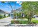Two-story home with a well-manicured lawn, teal garage door, and welcoming front porch at 13822 Darchance Rd, Windermere, FL 34786