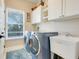 Well-lit laundry room featuring modern washer and dryer, utility sink, and ample cabinet space at 13822 Darchance Rd, Windermere, FL 34786