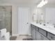 Bathroom featuring a double sink vanity, framed mirrors, and glass-enclosed shower for a luxurious feel at 14250 Sapelo Beach Dr, Orlando, FL 32827