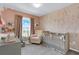 Charming Bedroom with crib, patterned wallpaper, and soft lighting, creating a cozy and inviting space at 14250 Sapelo Beach Dr, Orlando, FL 32827