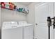 Bright laundry room with washer, dryer, shelving, and cleaning supplies at 14250 Sapelo Beach Dr, Orlando, FL 32827